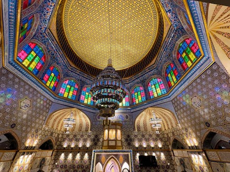 Luxurious mosque interior with colorful stained glass and intricate geometric patterns.