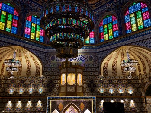Free Beautiful mosque interior displaying colorful stained glass and ornate chandeliers. Stock Photo