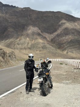 Motorcyclist on a Royal Enfield exploring the rugged landscapes of Leh, India.