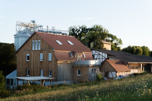 Free A picturesque wooden farmhouse in a rural setting during sunset. Stock Photo