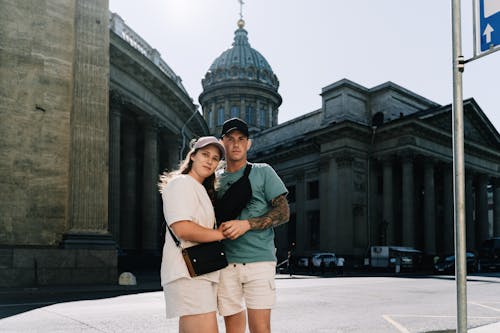 A young couple standing outside a historic cathedral on a sunny day.