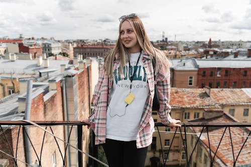 Stylová žena na střeše s výhledem na město