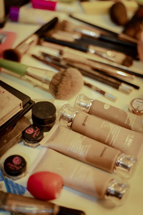 Free Close-up of various cosmetic items and brushes arrayed on a table. Stock Photo