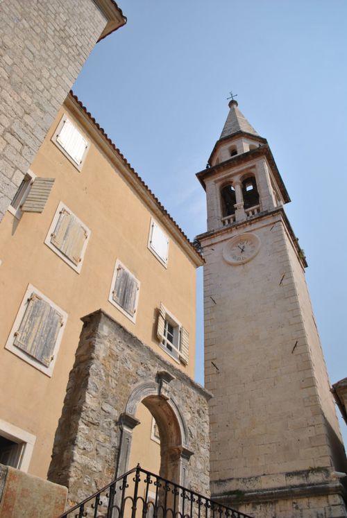 Free A beautiful historic bell tower and stone buildings under a clear sky. Stock Photo