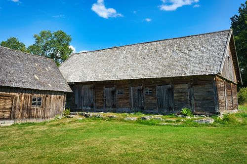 Free Charming wooden barns with thatched roofs in Skåne, Sweden, under clear blue skies, showcasing rural Swedish architecture. Stock Photo