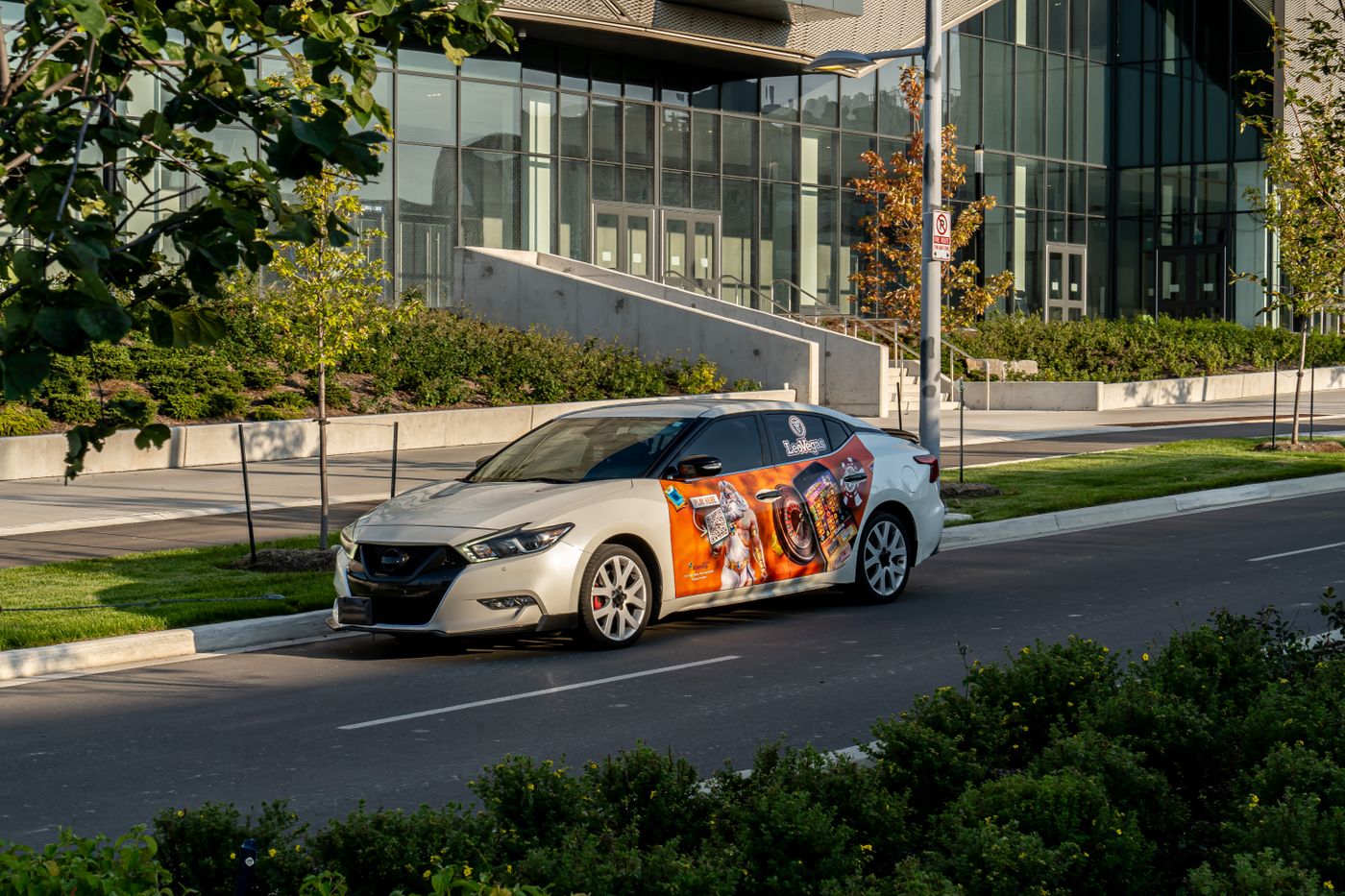 Car with full custom vinyl advertising wrap parked on a city street