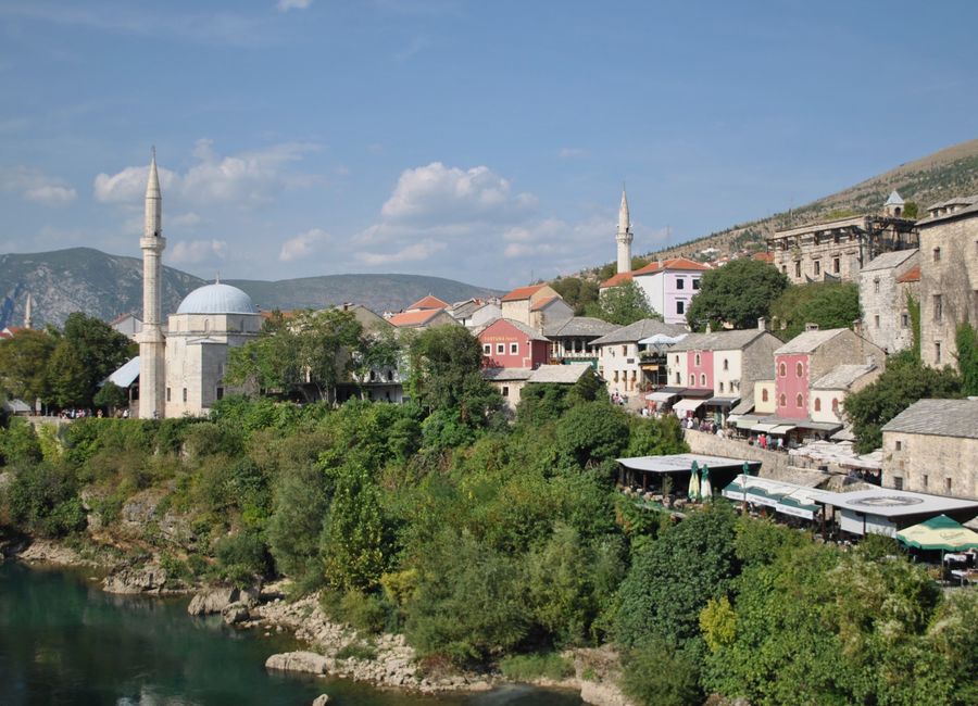Beautiful view of Mostar's Old Town with Neretva river and minarets under a blue sky.
