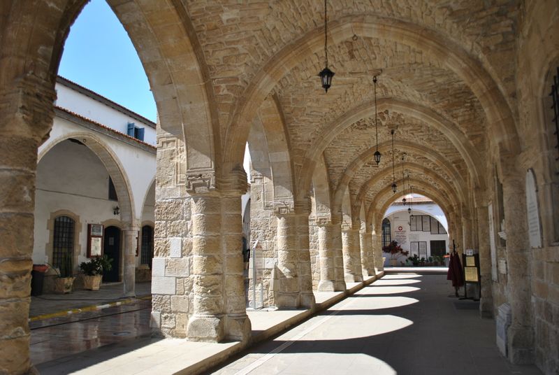 Sunlit stone cloister with a run of arches — Valeria Drozdova on Pexels
