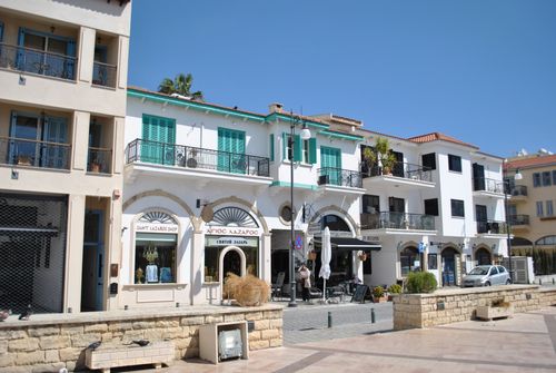 Free Charming Mediterranean street with colorful shops and cafes under a sunny blue sky. Stock Photo