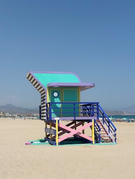 Colorful lifeguard tower on a sunny beach with clear blue skies.