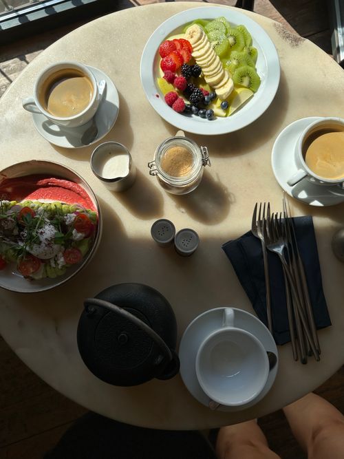 Free Aerial view of a colorful breakfast with fruit, coffee, and salad on a marble table. Stock Photo