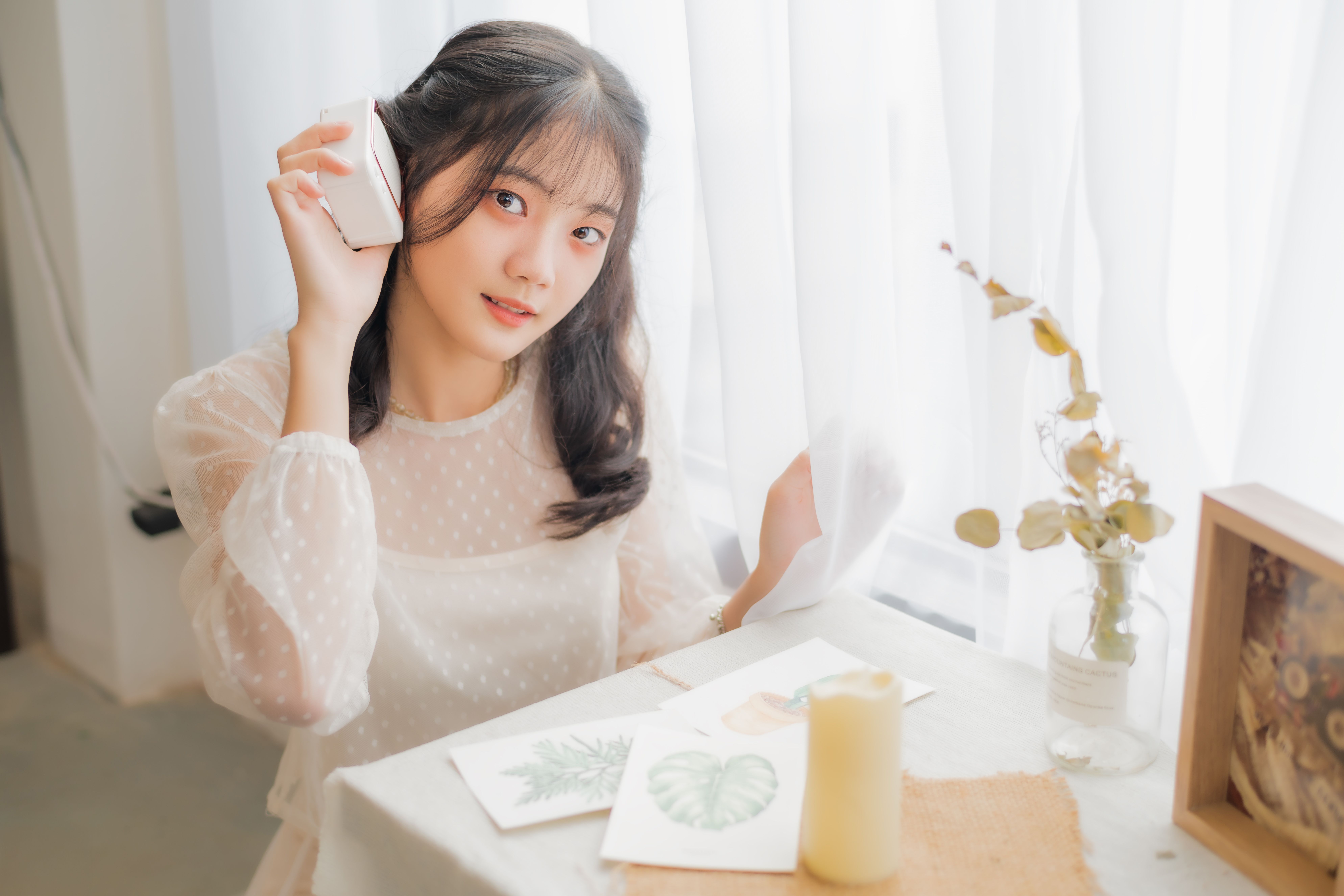Young woman wearing lace top, enjoys a crafting session indoors with natural light and decor.