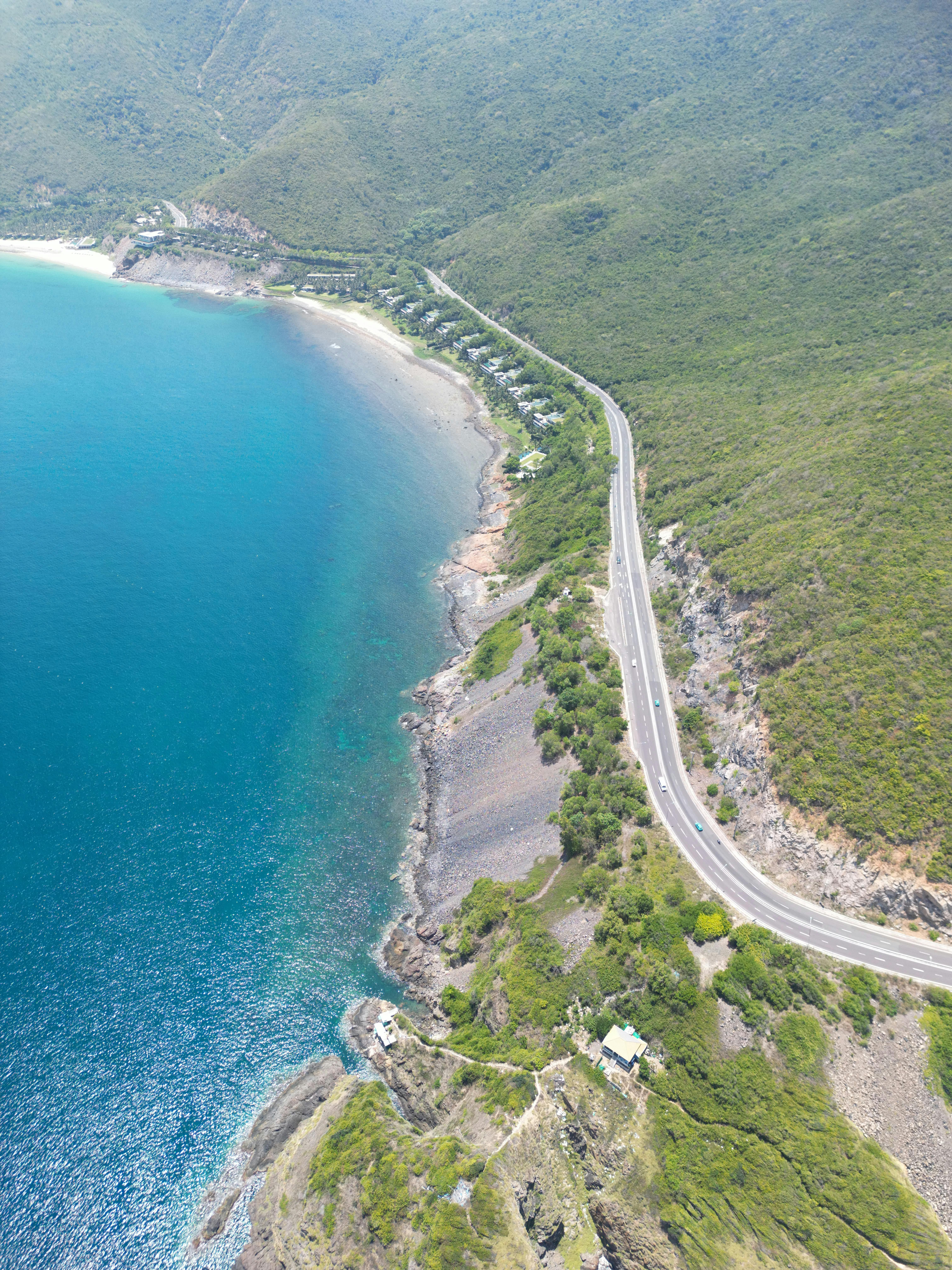 무료 베트남의 아름다운 풍경 속의 해안 도로와 청록색 만의 경치를 공중에서 본 모습입니다. 스톡 사진