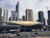 迪拜的地铁站采用未来派设计，与背景中的标志性摩天大楼共同展现了现代建筑的魅力