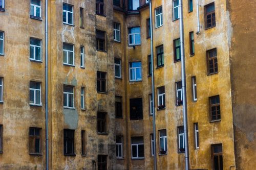 Free Urban apartment building showing age with a rustic, weathered facade and multiple windows. Stock Photo