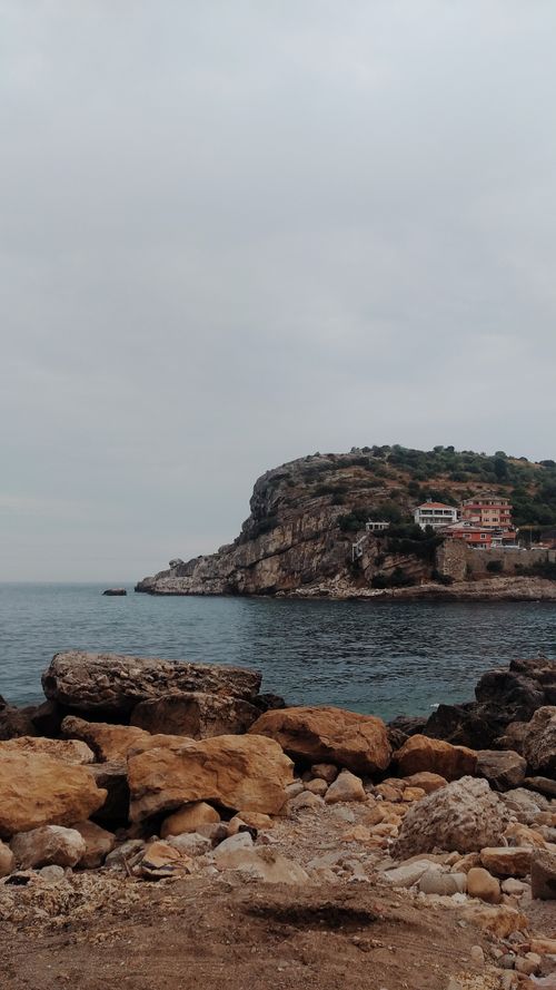 Free A breathtaking view of Amasra's rugged coastline with rocky shores and cloudy skies. Stock Photo