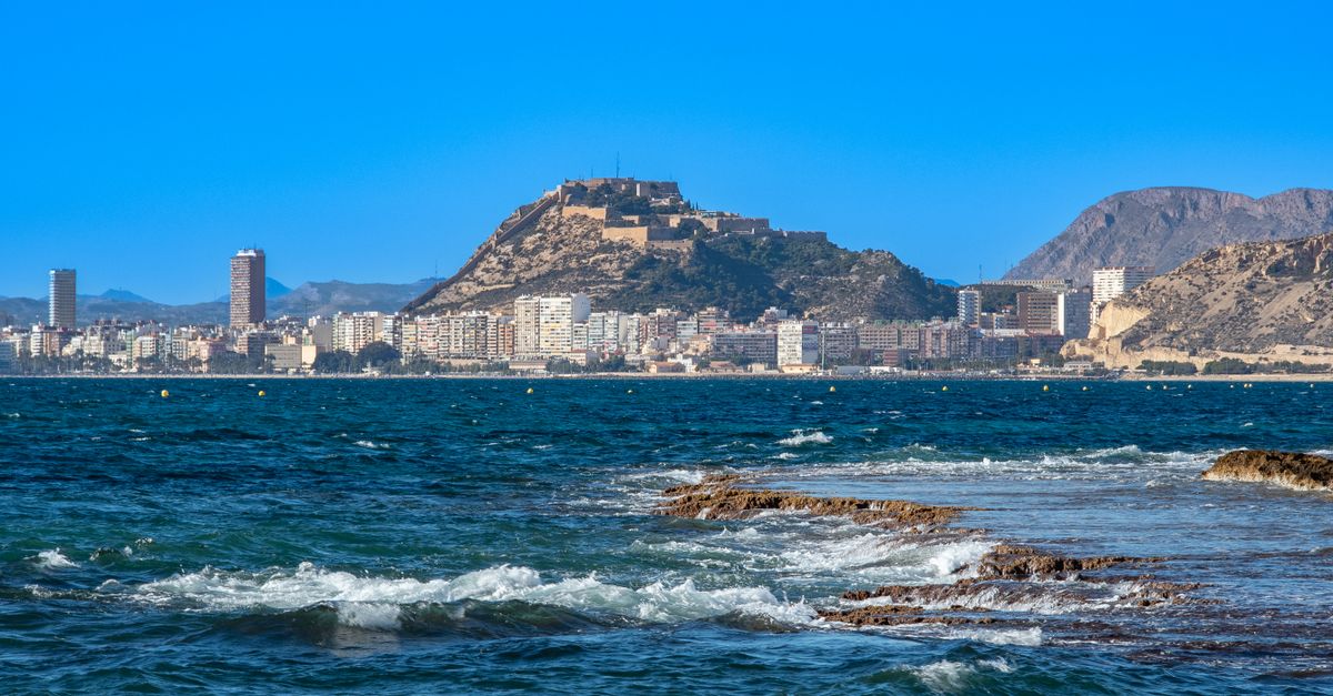 Vista costera de Alicante con el Castillo de Santa Bárbara al fondo y el mar Mediterráneo en primer plano