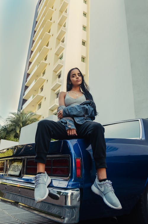 Woman Sitting on a Car's Hood