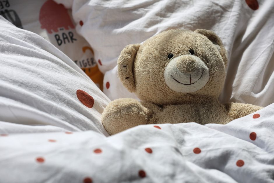 Sypialnia z ciężkimi zasłonami, roletą i stonowanymi barwami sprzyjającymi wyciszeniu