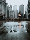 潮湿的人行道上映照着城市天际线，为城市增添了戏剧性的氛围