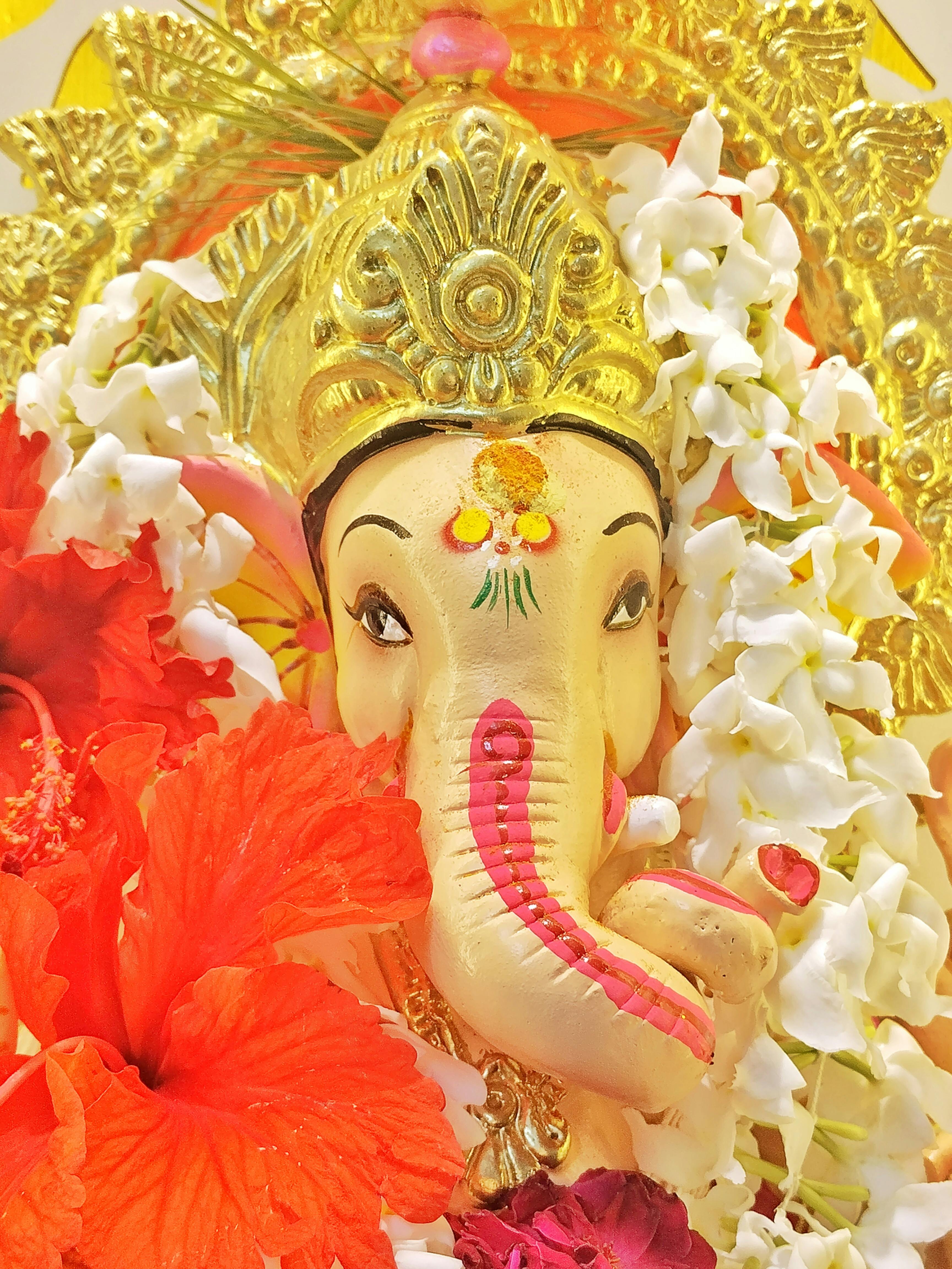 Captivating Ganesh idol adorned with vibrant flowers, symbolizing spirituality and festivity.