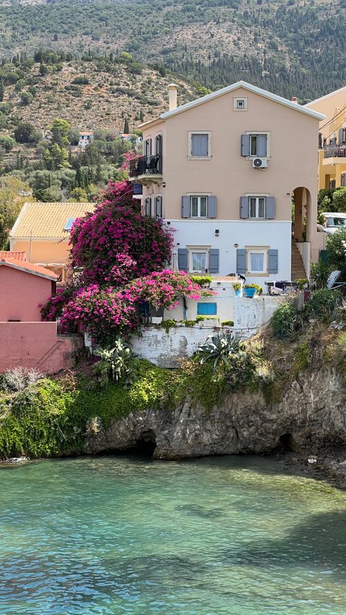 Free Picturesque house by the sea with blooming bougainvillea under a clear sky. Stock Photo