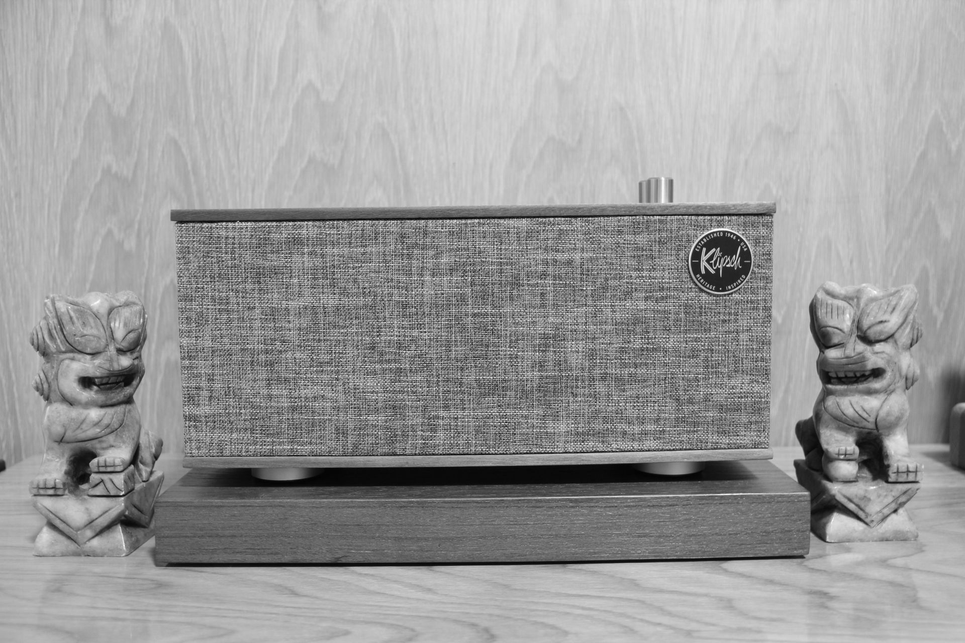 A vintage Klipsch speaker with Tiki statues, perfect for retro decor enthusiasts.