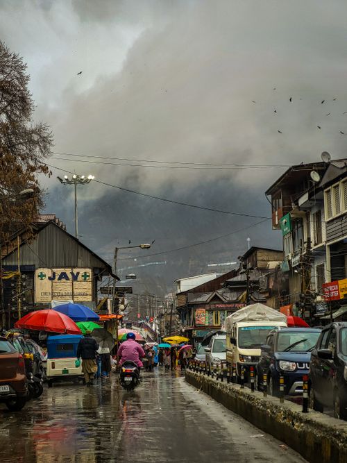 Free A bustling street scene with colorful umbrellas on a rainy day in an urban area, showcasing daily life. Stock Photo