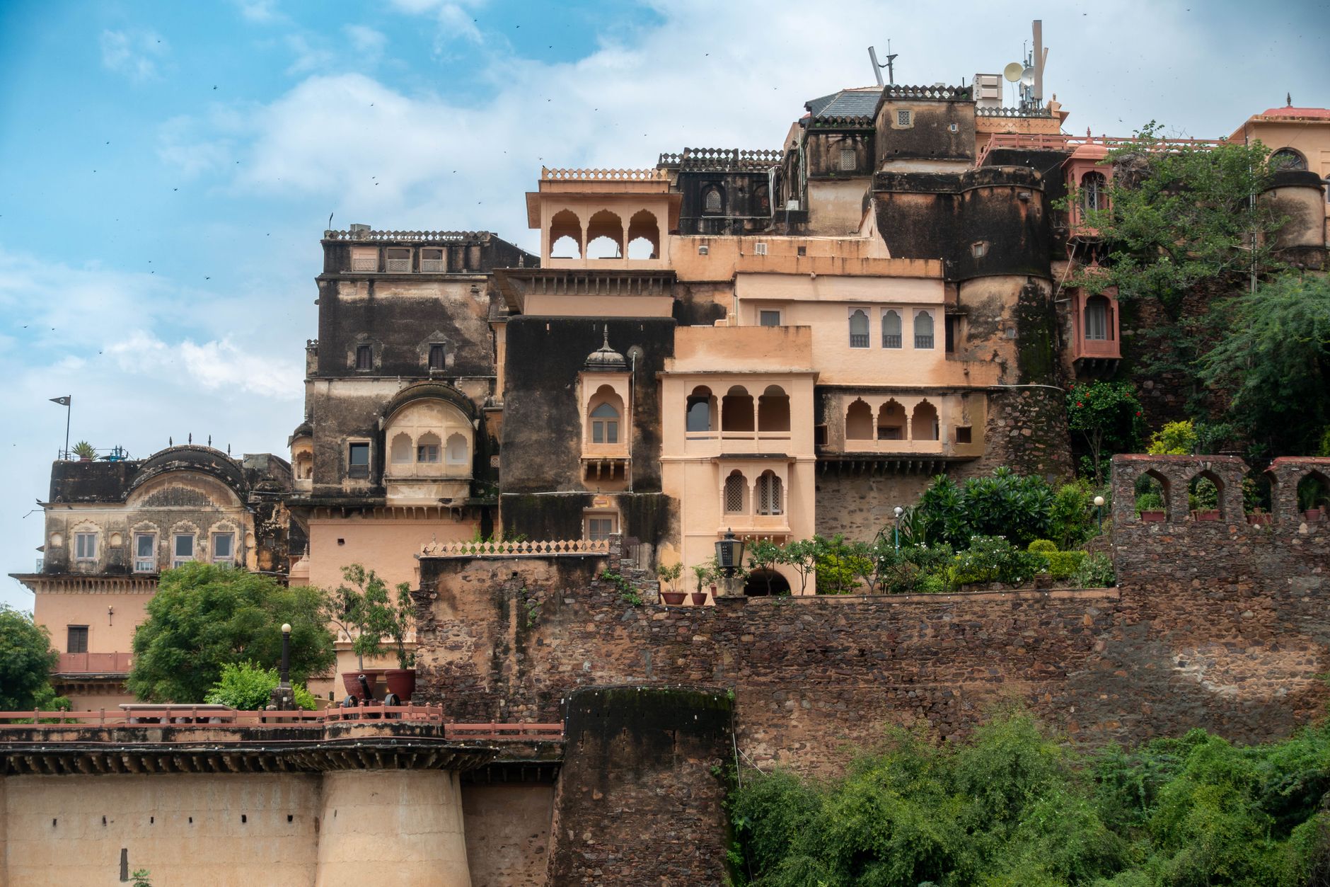 Terraced sandstone fort palace built into an Aravalli hillside