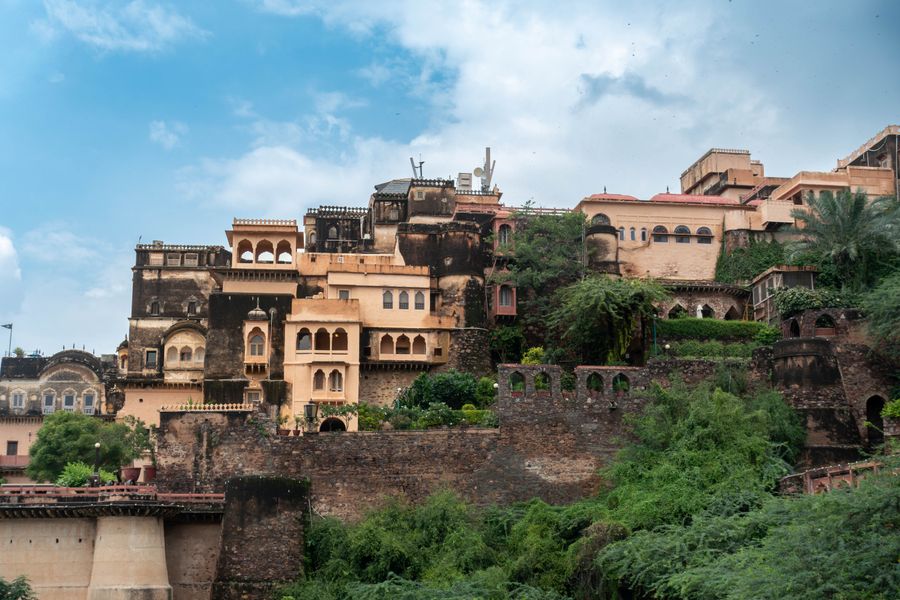 Captivating view of Neemrana Fort-Palace amidst lush greenery under a bright blue sky.