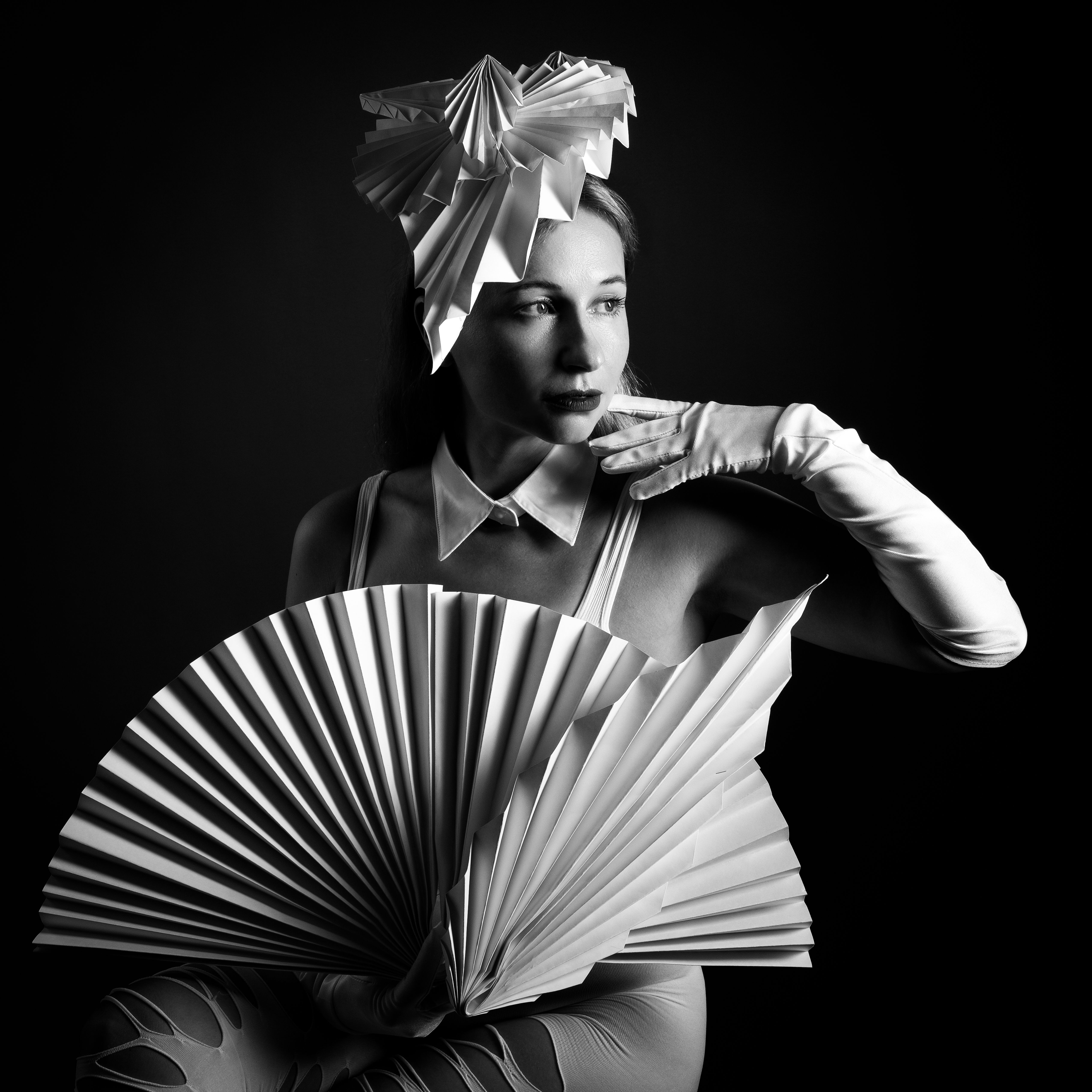 Striking black and white portrait featuring a woman with elegant origami accessories.
