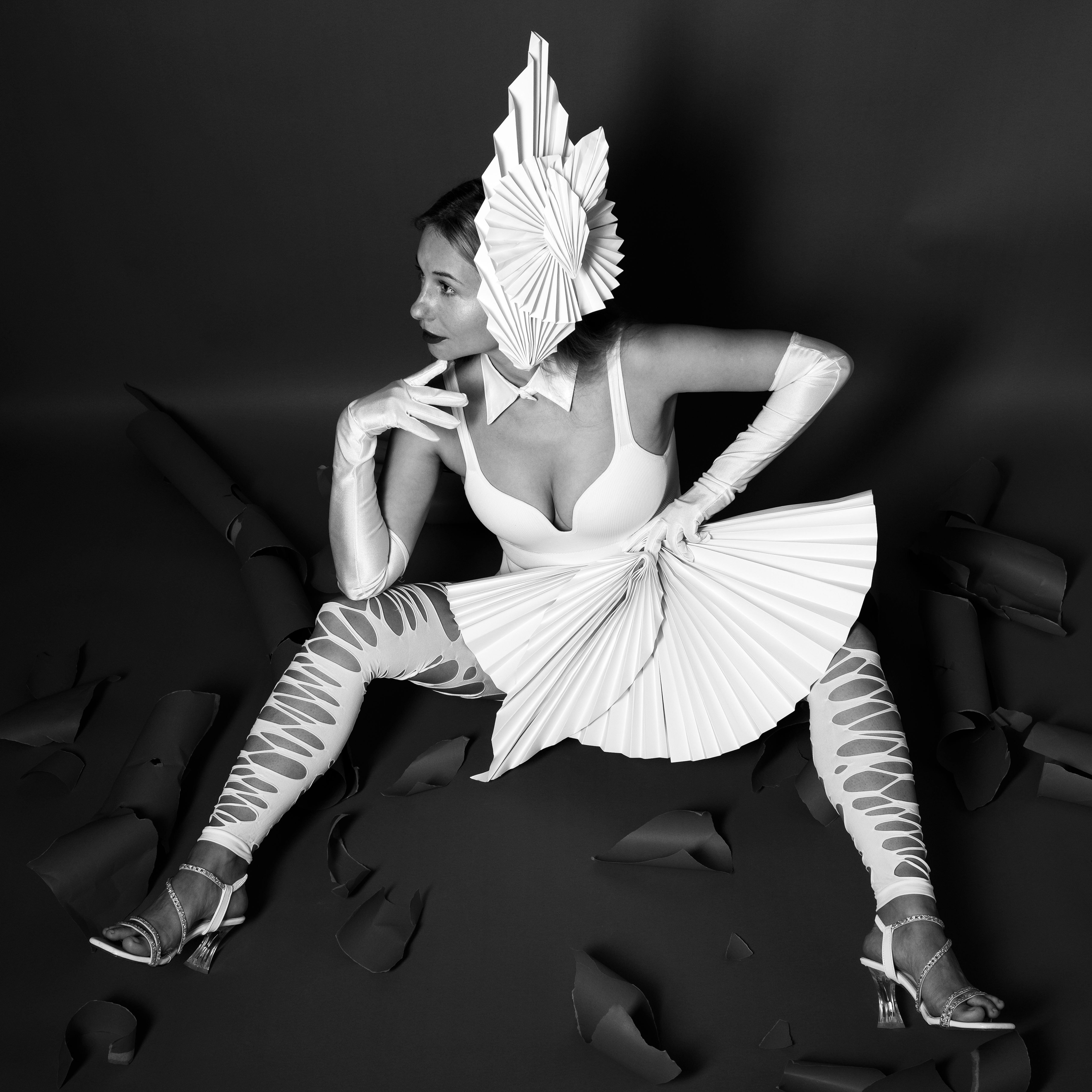 Striking avant-garde fashion portrait of a woman in a creative paper outfit.