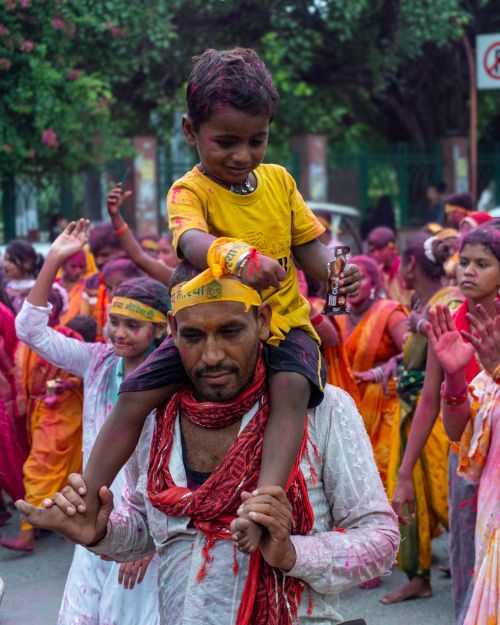 Free A vibrant scene of a father and son enjoying the Holi festival in Lucknow, India. Stock Photo