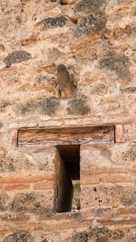 Detail of an ancient stone wall in Pompeii, capturing historic architecture.