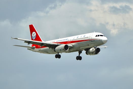 A Sichuan Airlines aircraft gracefully flies through a cloudy sky, showcasing its red and white design.