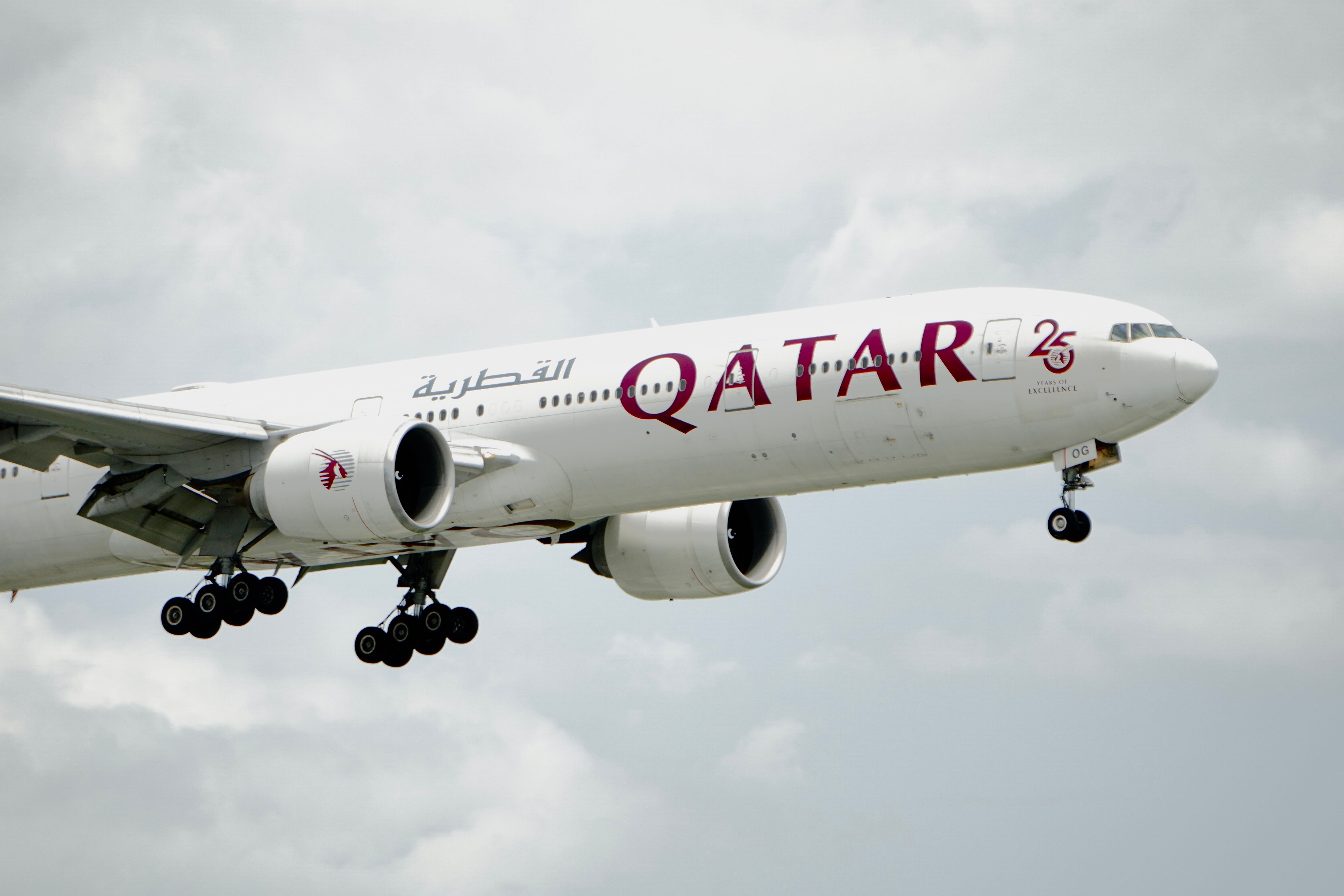 Qatar Airways Aircraft in Flight with Cloudy Sky · Free Stock Photo