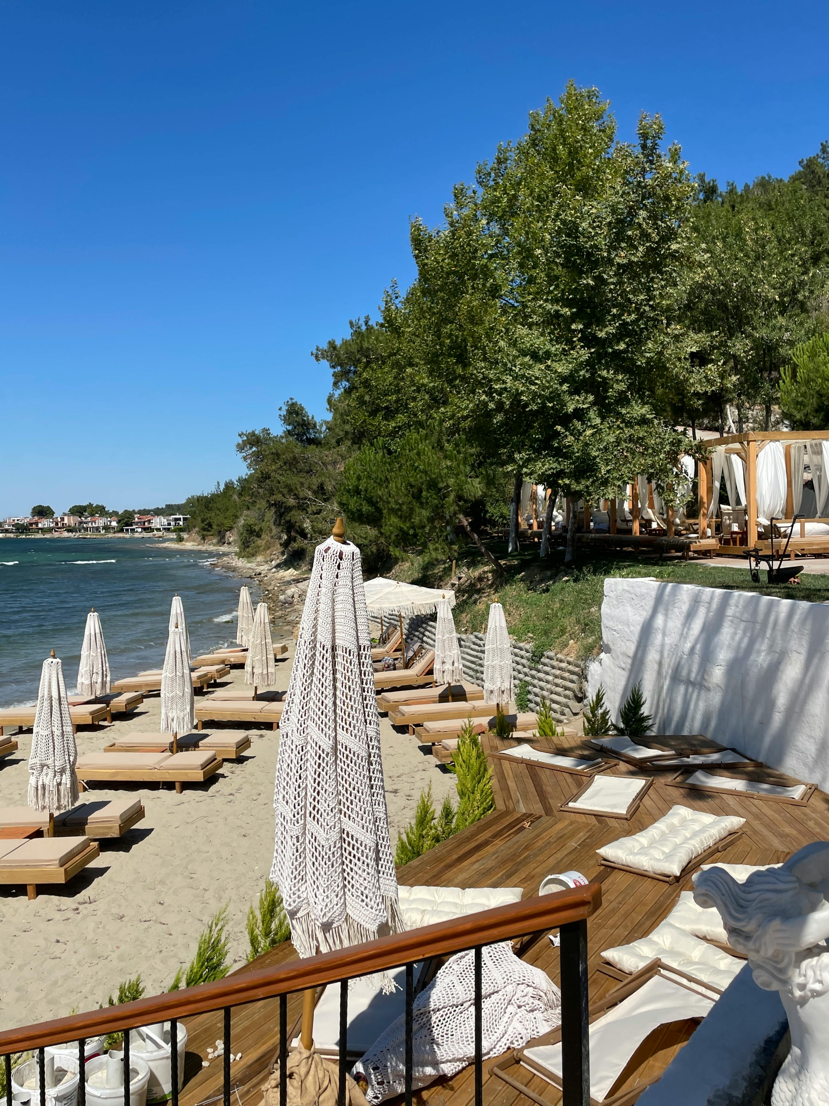 A serene Mykonos beachfront lounge with sun umbrellas