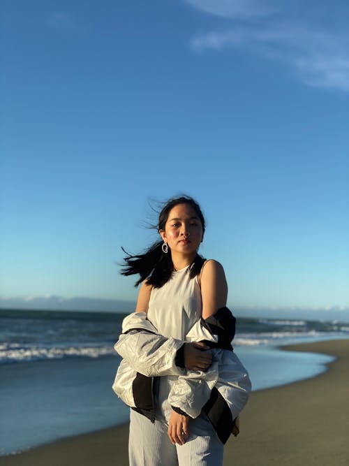 Woman in White Sleeveless Dress Standing on Beach