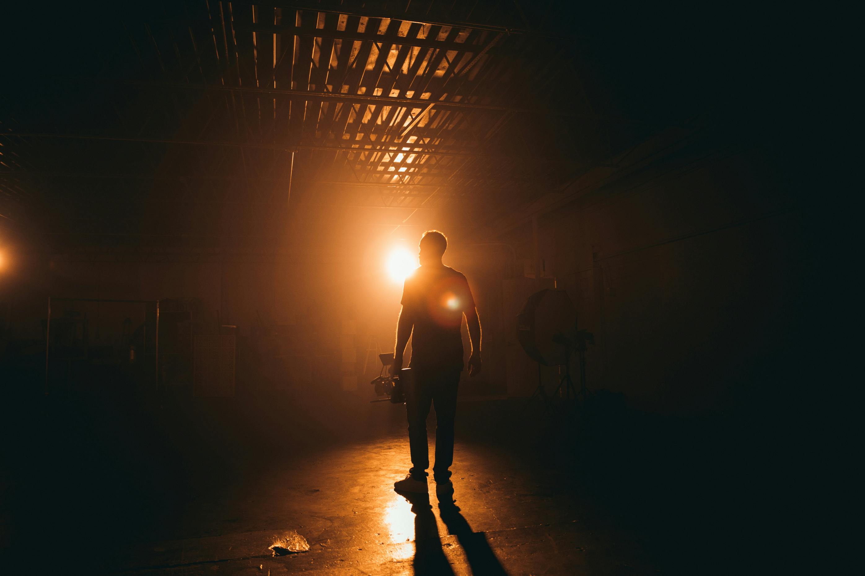 silhouette photography unknown person standing indoors