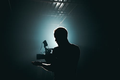 Free Silhouette of Man Standing in Front of Microphone Stock Photo