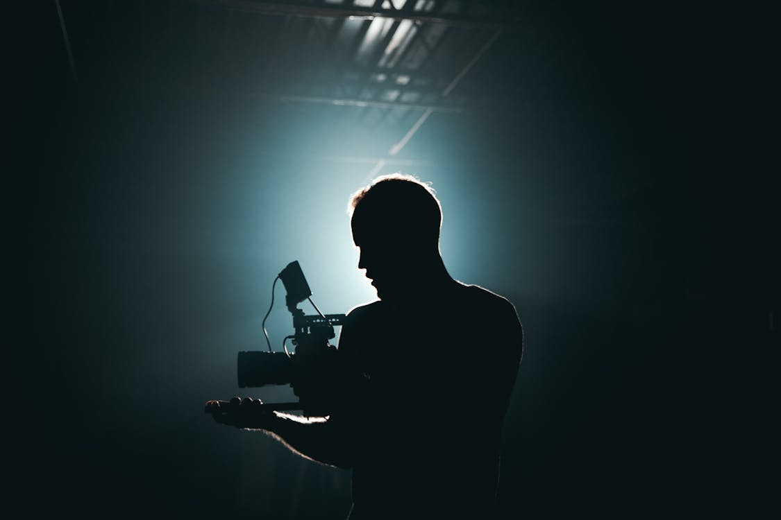 Free Silhouette of Man Standing in Front of Microphone Stock Photo