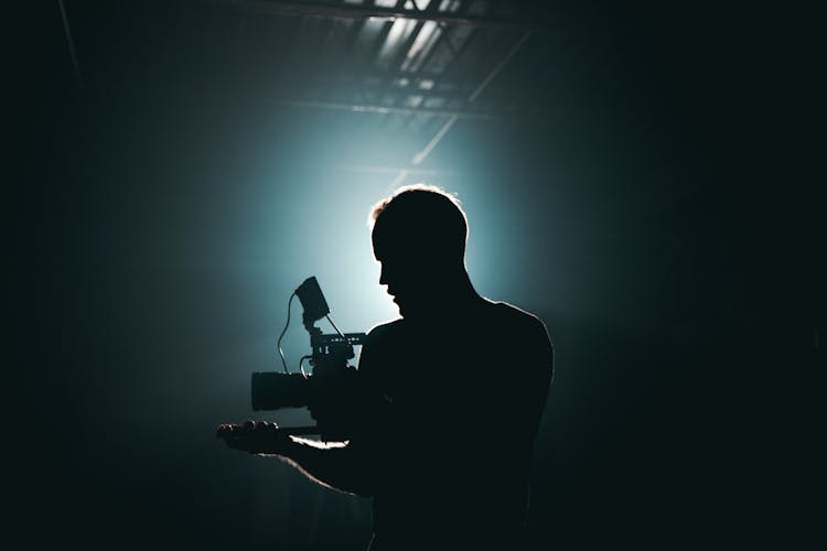 Silhouette Of Man Standing In Front Of Microphone