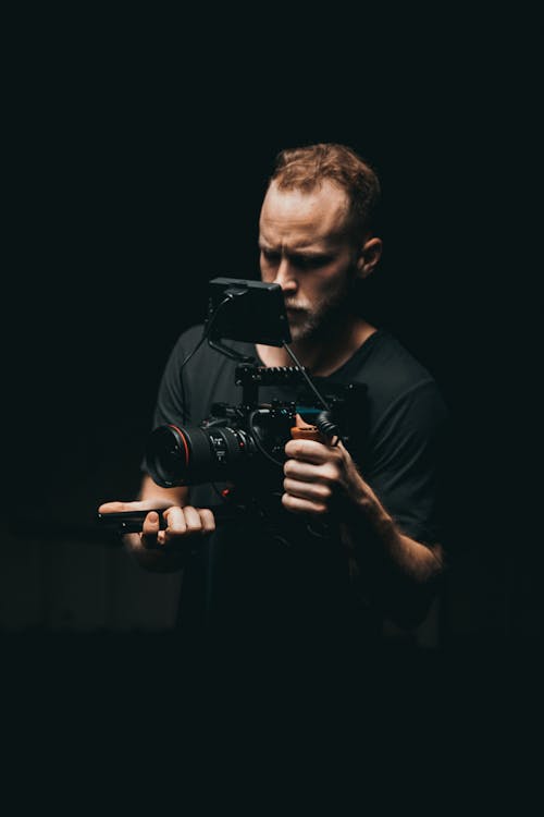 Shallow Focus Photo of Man Wearing Black Dslr Camera