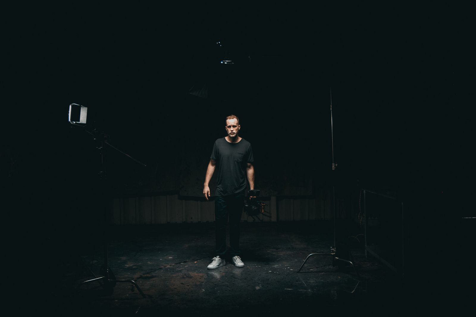 A cinematographer standing in a dimly lit sound stage — photo by Kyle Loftus on Pexels