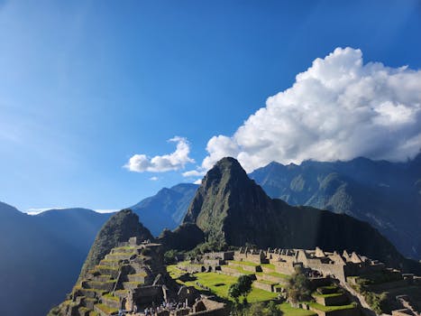 Sunny day at Machu Picchu with clear blue skies and ancient ruins.
