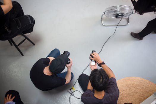 Two photographers are captured from above, engaged in a photo session in a studio environment.