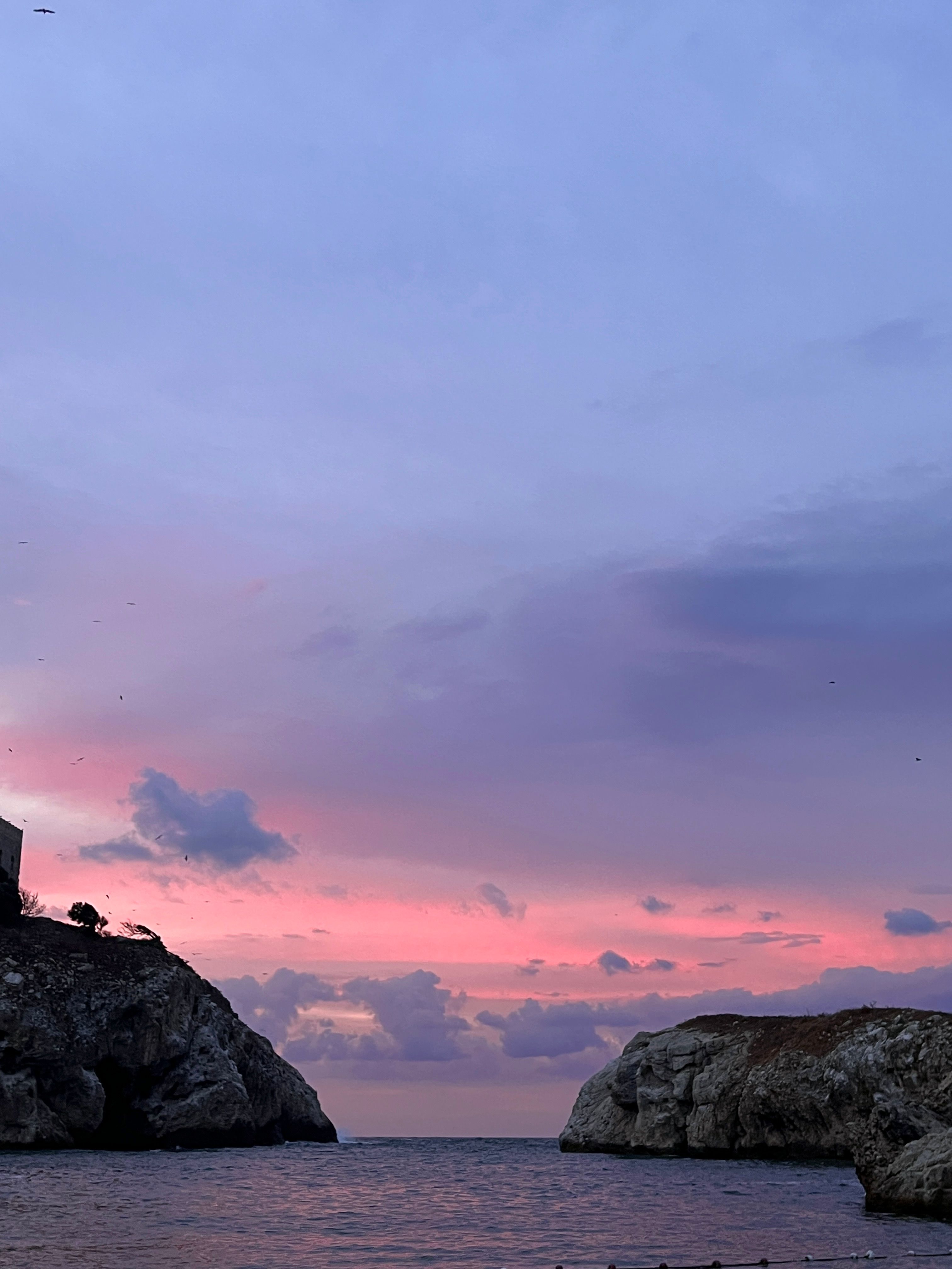 Breathtaking sunset over Şile's rocky shores, showcasing pink and purple skies meeting the calm sea.