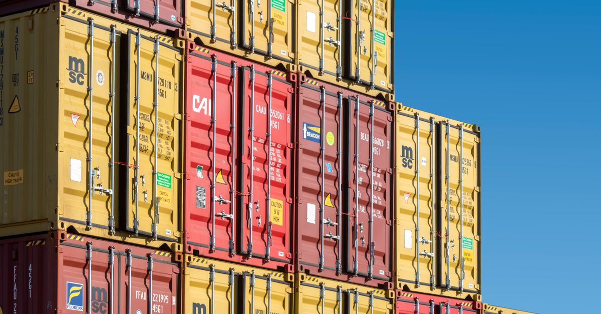 Photo by Jan van der Wolf Colorful shipping containers stacked against a clear blue sky, representing global trade and transportation.