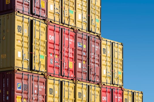 Colorful shipping containers stacked against a clear blue sky, representing global trade and transportation.