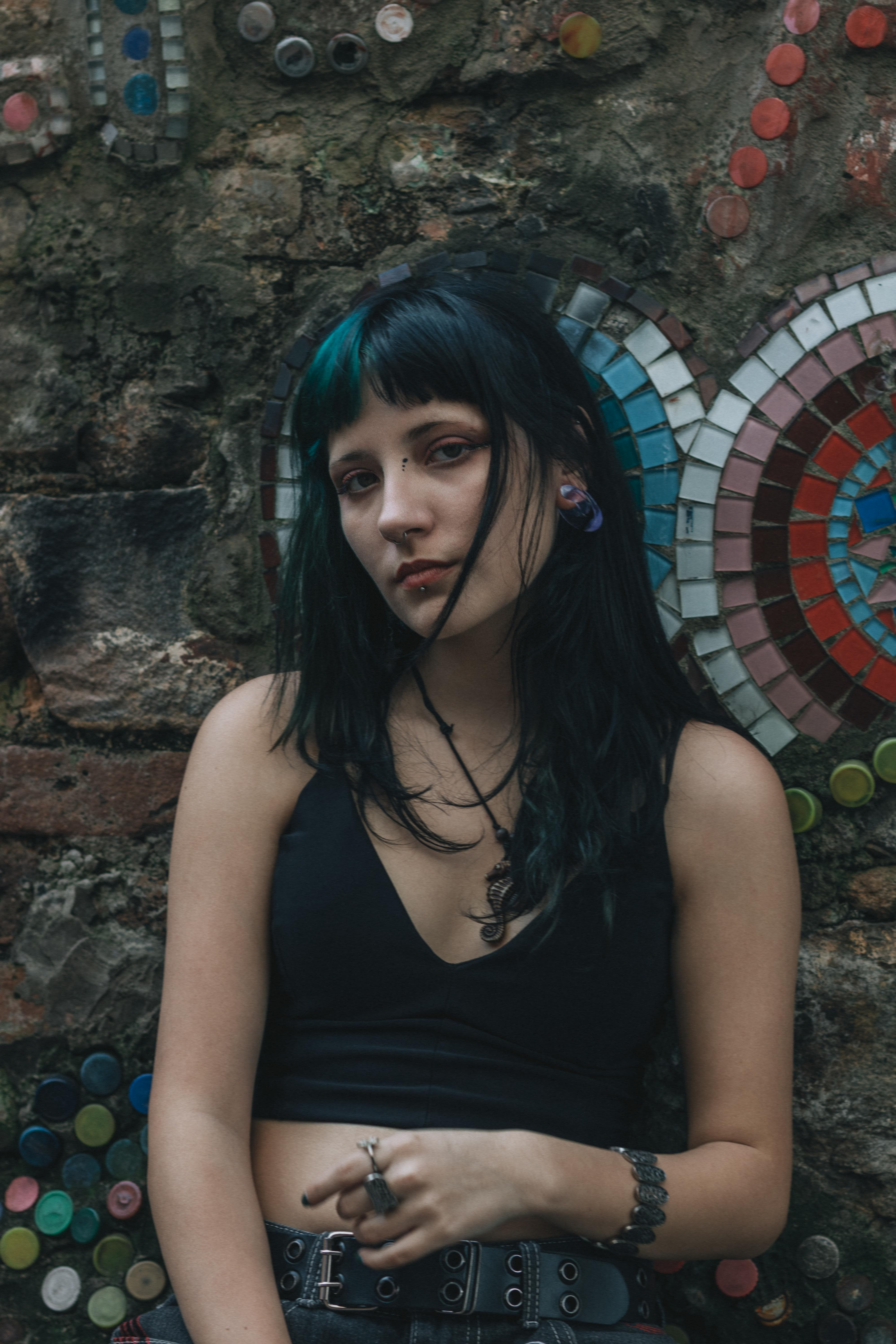 ingyenes Egy fiatal nő művészi portréja mozaikos háttérrel, hangulatos és sötét hangulatot sugározva. Stockfotó